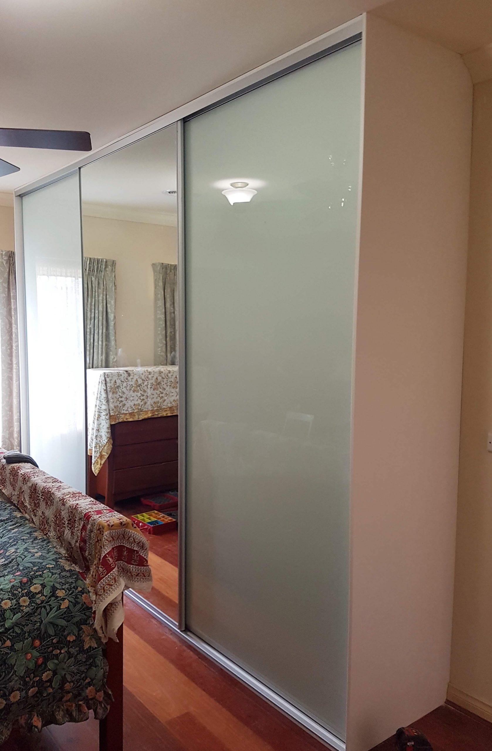 Sliding wardrobe doors in white glass framed mirror doors