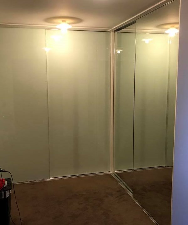 sliding wardrobe doors in a corner wardrobe with glass and mirror doors