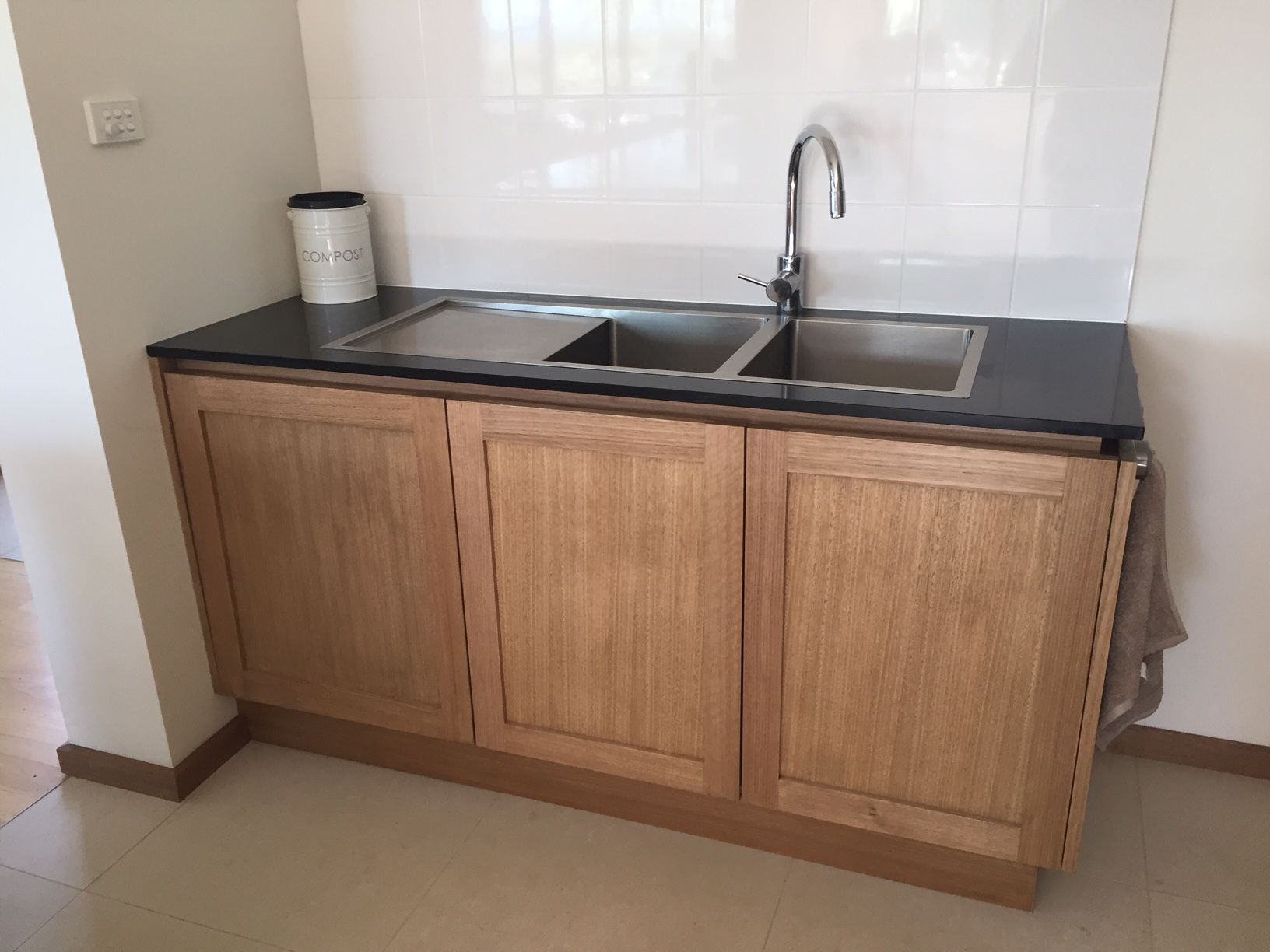 laundry with stone benchtop and timber veneer cupboards