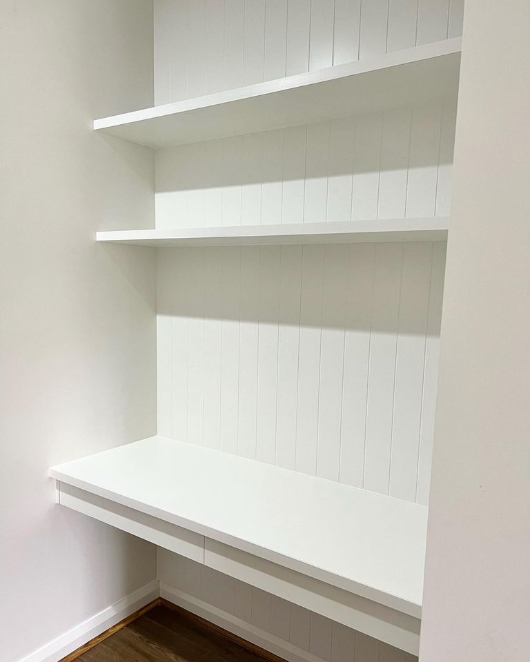 built in thin white desk with overhead shelves