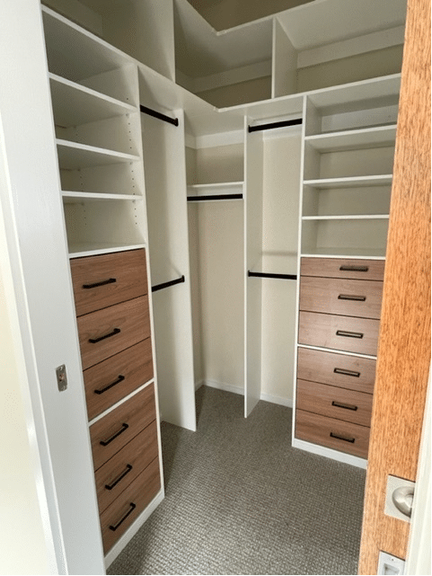 corner walk in wardrobe - white hanging and shelves with timber laminat draws