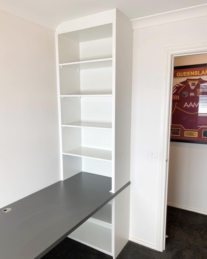 grey built in study desk with white built in storage shelves