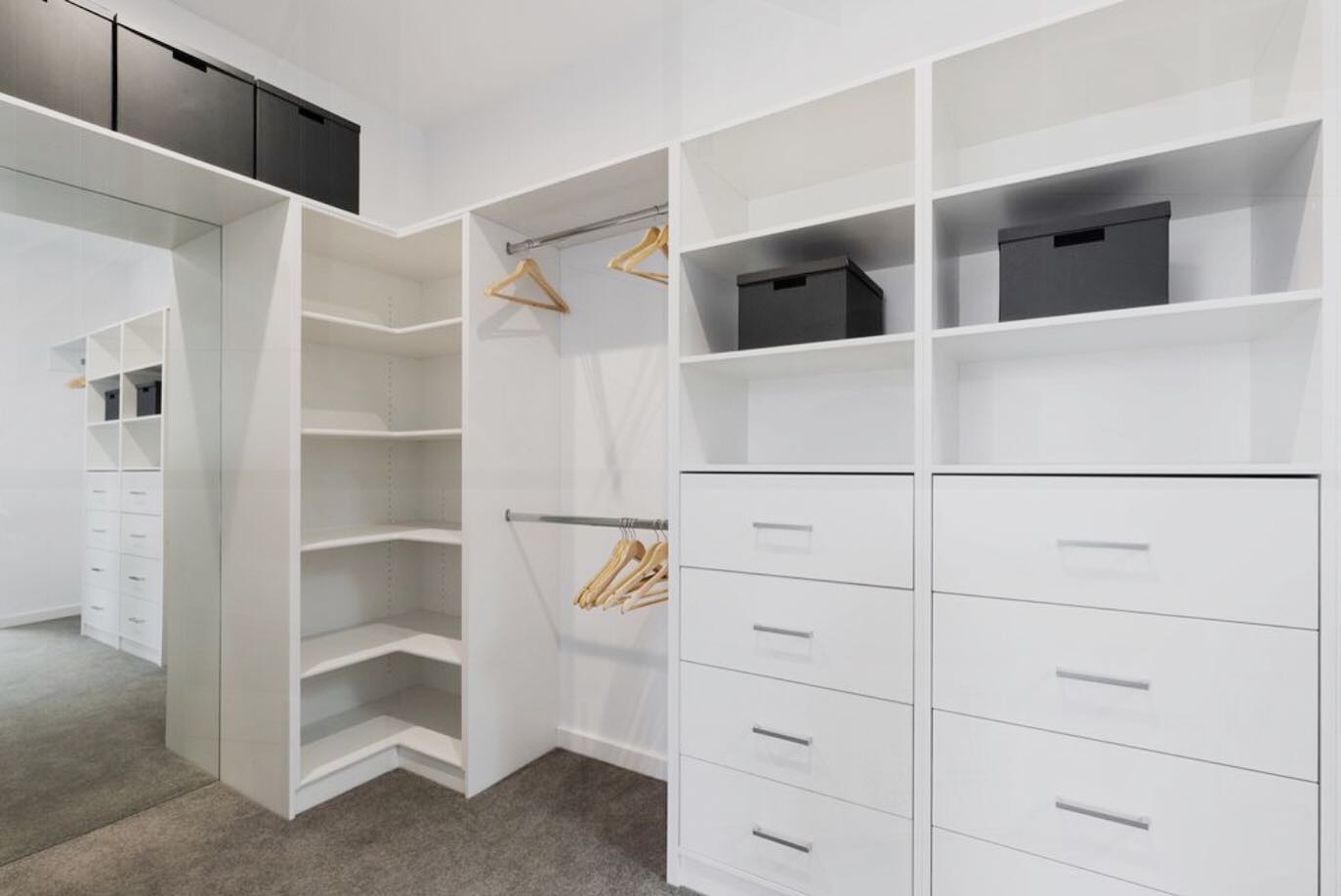 large white walk in wardrobe with full length mirror shelves draws and hanging and storage up the top