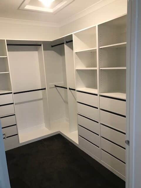 walk in wardrobe - lots of draws, shelves and black hanging rails