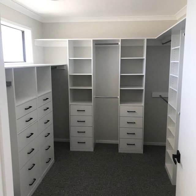 white walk in wardrobe - lots of hanging space - shelves and draws with black handles 1